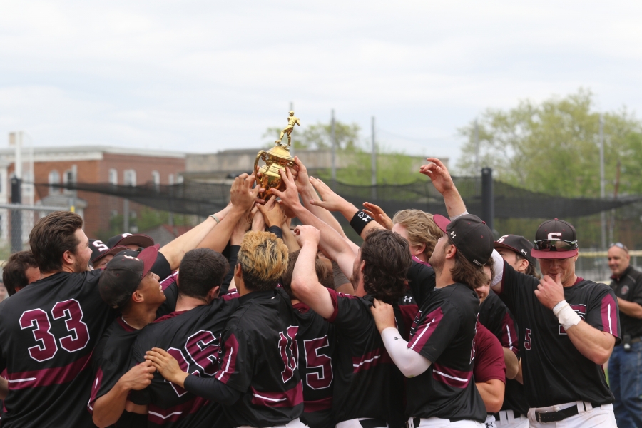 baseball players hold a trophy aloft